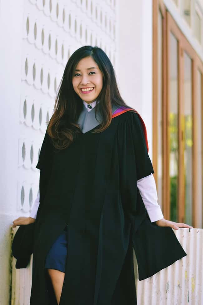 Smiling college graduate wearing graduation robe